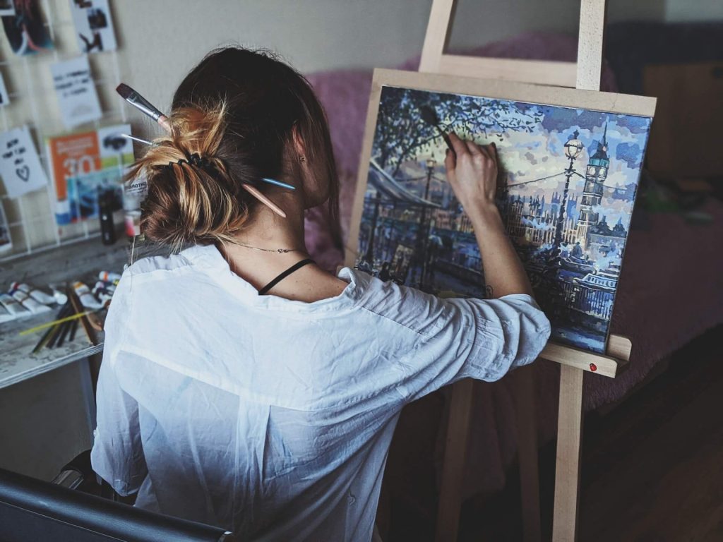L'immagine di una donna intenta a dipingere, che esprime la propria creatività e passione attraverso l'arte.
